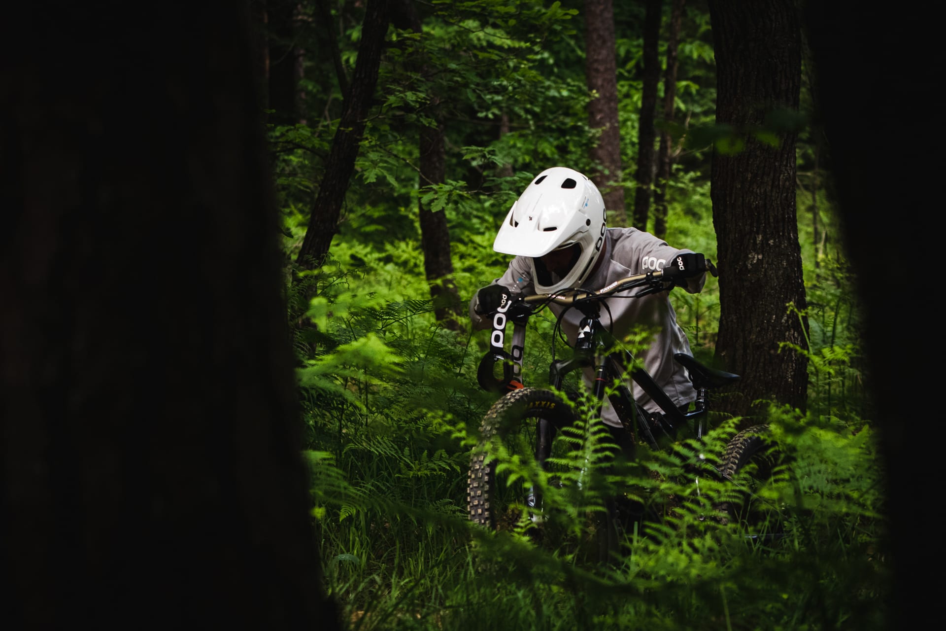 BineZalohar@KeepBusybyLegitFilms©KatjaPokorn Lifestyle shot of a mountain biker hiking uphill in the spring green forest and pushing his bike