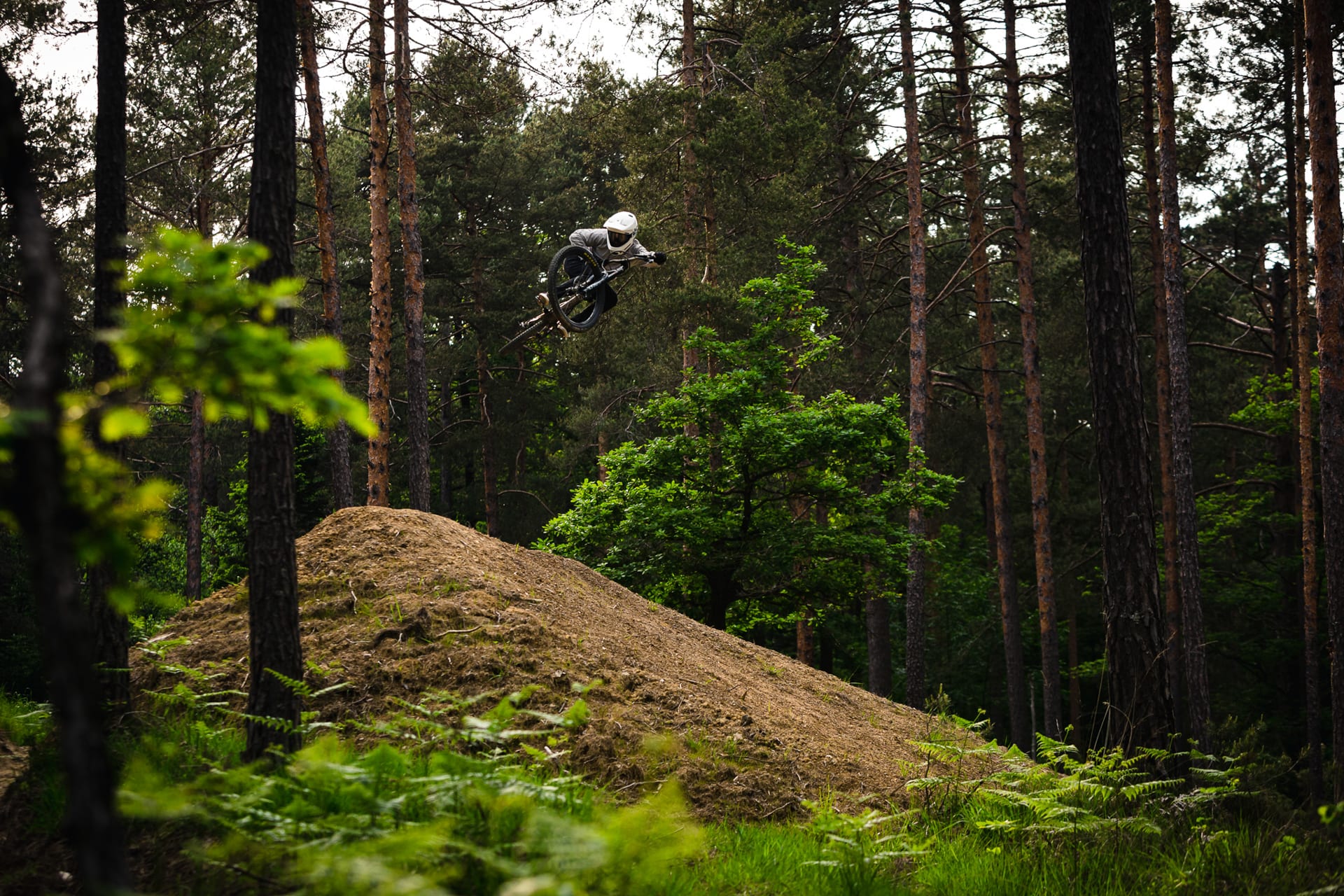 BineZalohar@KeepBusybyLegitFilms©KatjaPokorn Mountain biker on a huge jump on forest MTB trail